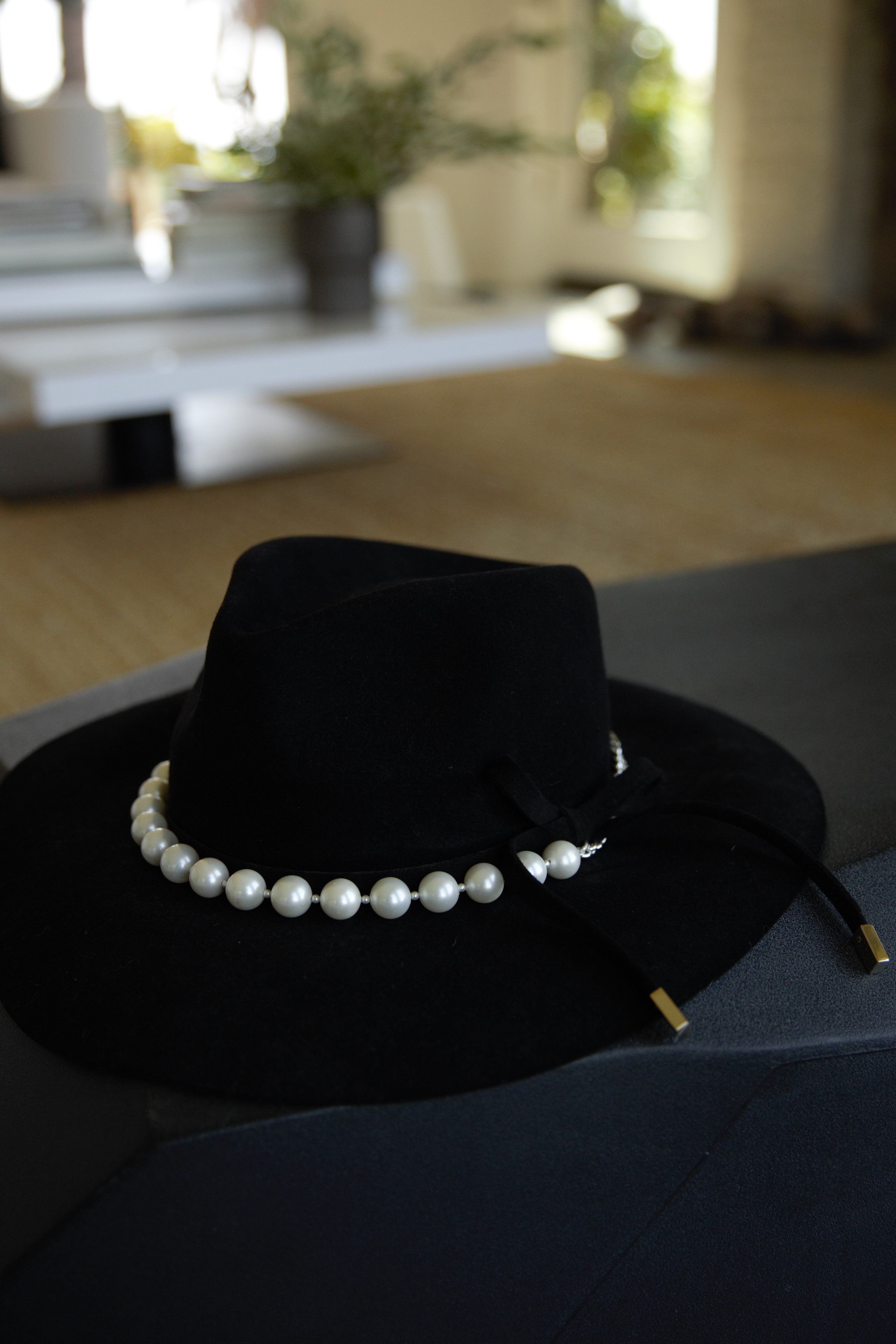 Black hat featuring the white pearl hat band