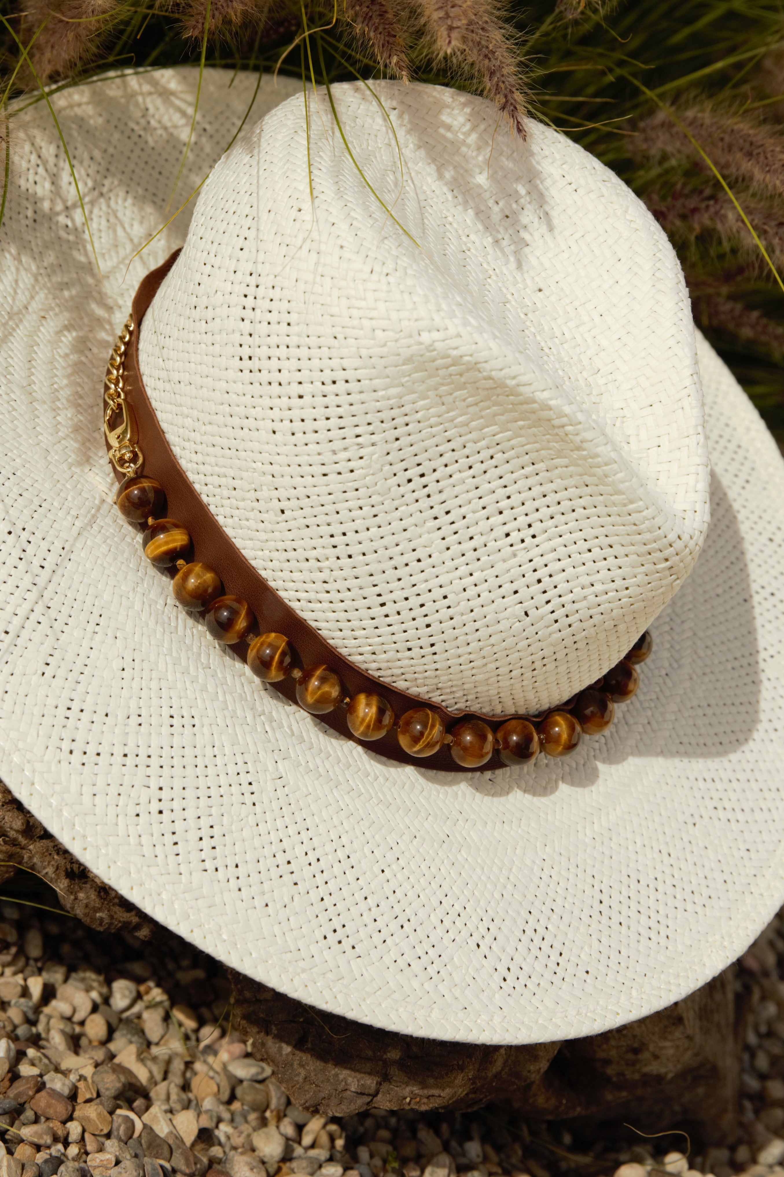 Straw hat featuring the tiger's eye hat band with brass chain