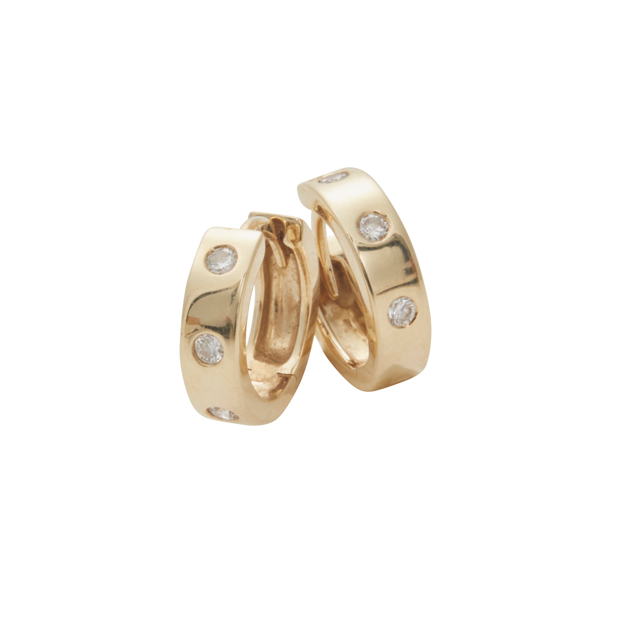 Yellow gold huggies containing 3 diamonds from Jeuje Jewelry on a white background