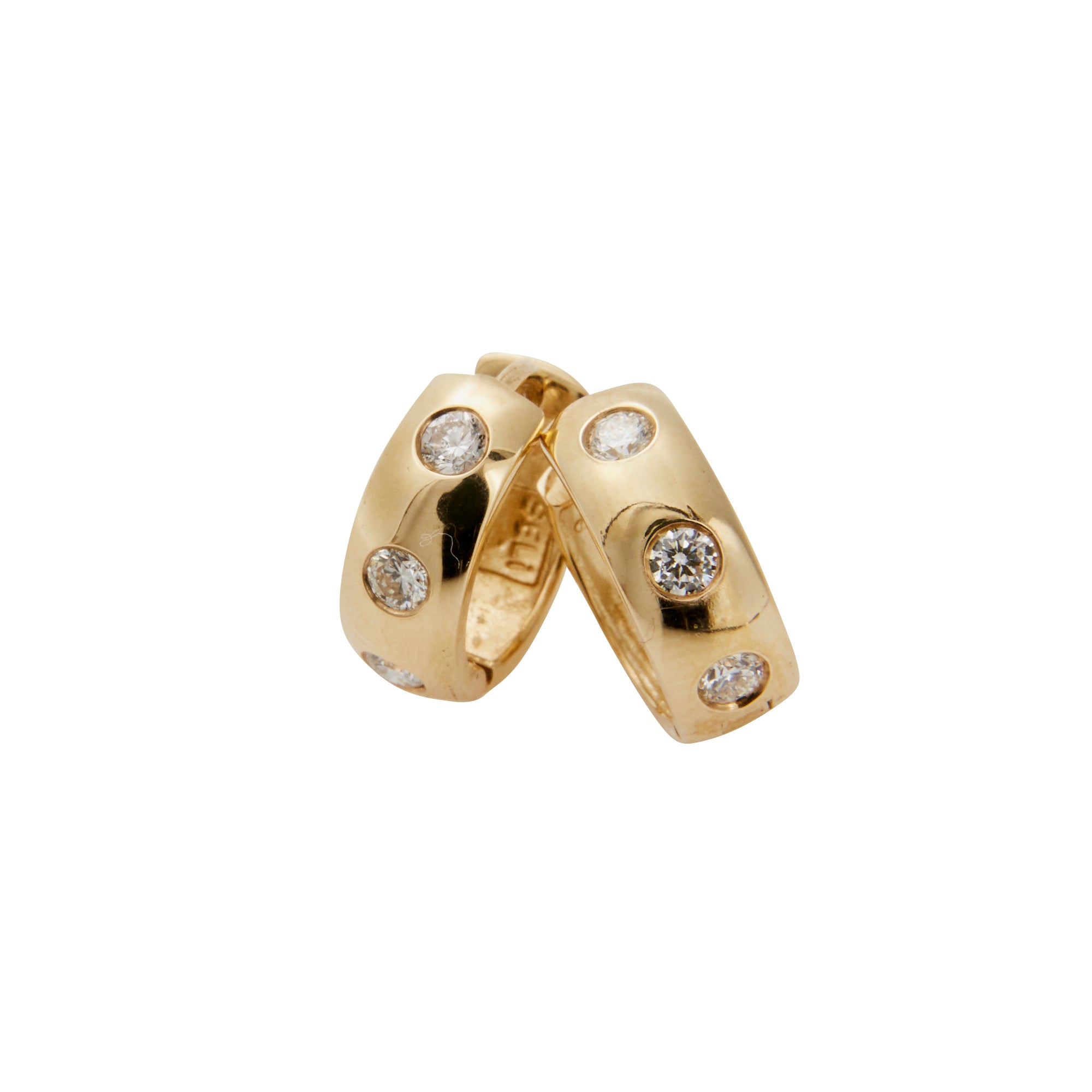 Large yellow gold huggies containing 3 diamonds leaning against each other from Jeuje Jewelry on a white background